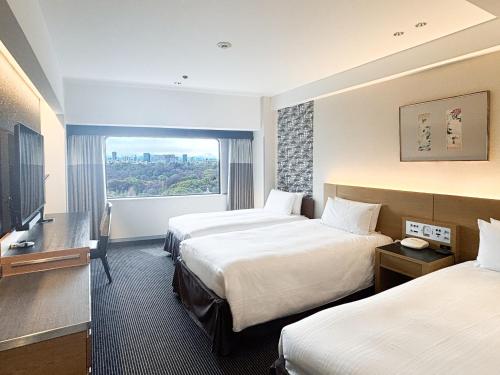 a hotel room with two beds and a window at Hotel New Otani Tokyo Garden Tower in Tokyo