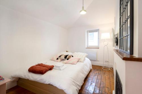 une chambre avec un lit avec des draps blancs et une fenêtre dans l'établissement Studio Secundo, à Metz