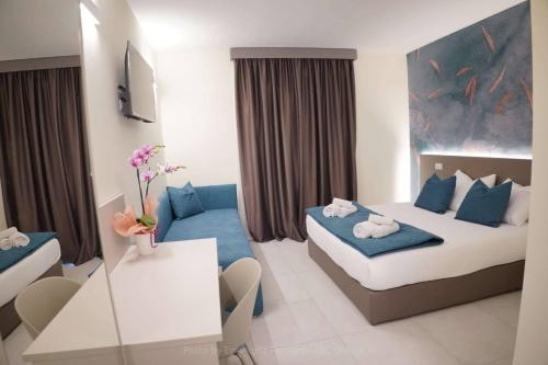 a small hotel room with a bed and a couch at La Gioconda in Cascia