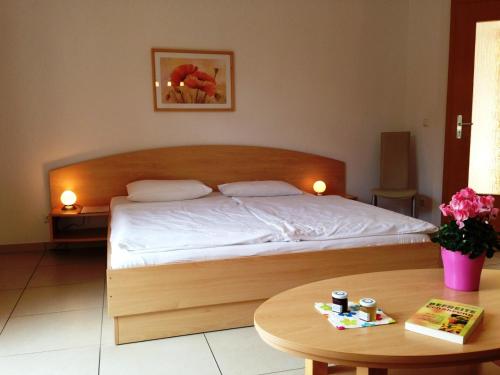a bedroom with a large bed and a table at Apartment Am Lübbesee in Templin