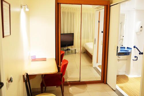 a room with a table and a glass door leading to a bedroom at Hotel De Rosny in Tours