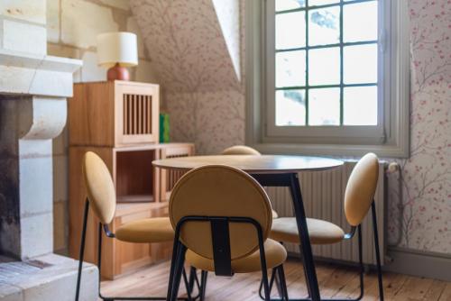 une table et des chaises dans une pièce avec une fenêtre dans l'établissement Appartement Spacieux Dépendance château Vue Loire, à Gennes