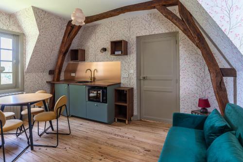 un salon avec un canapé bleu et une table dans l'établissement Appartement Spacieux Dépendance château Vue Loire, à Gennes