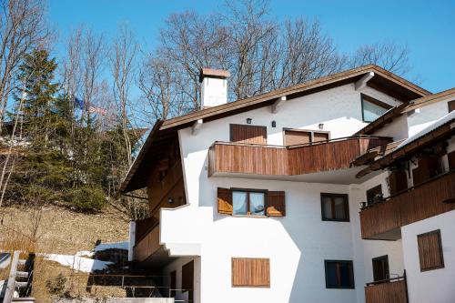 a white building with wooden balconies on it at Villa Franchetti - Stayincortina in Cortina dʼAmpezzo