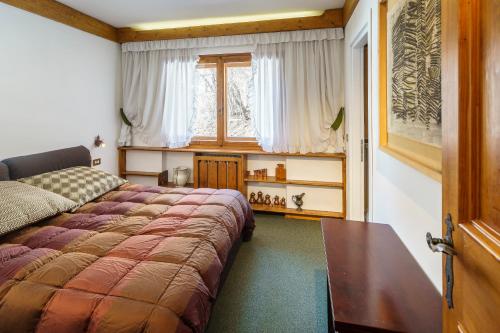 una camera con letto e finestra di Villa Franchetti - Stayincortina a Cortina dʼAmpezzo