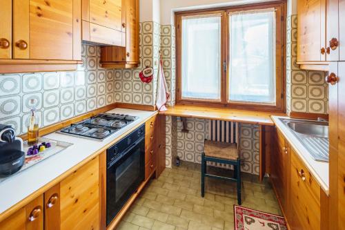 a kitchen with wooden cabinets and a stove top oven at Villa Franchetti - Stayincortina in Cortina dʼAmpezzo