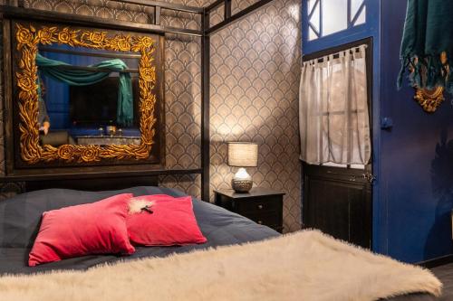 una camera da letto con un cuscino rosso su un letto con specchio di Love Room, La Parenthèse, Auxerre ad Auxerre