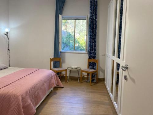 a bedroom with a bed and a window and two chairs at Bellavista in Selva di Fasano