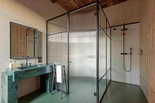 a bathroom with a glass shower and a sink at Palazzo Petrvs in Orvieto