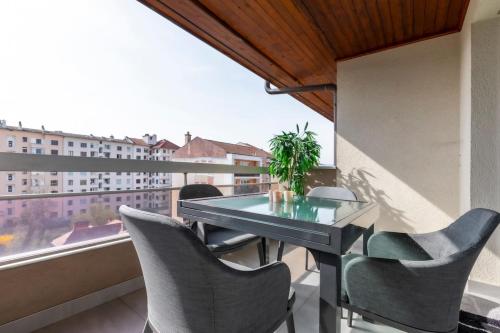 un balcon avec une table, des chaises et une fenêtre dans l'établissement Résidence L'Ecrin - Appartement en Centre ville, à Annecy