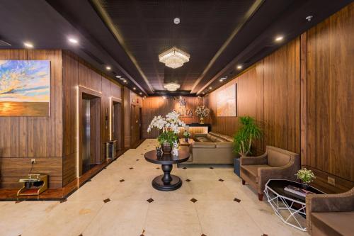 eine Lobby mit Holzwänden und einem Tisch mit Blumen in der Unterkunft Sana Da Nang Beach Hotel in Đà Nẵng