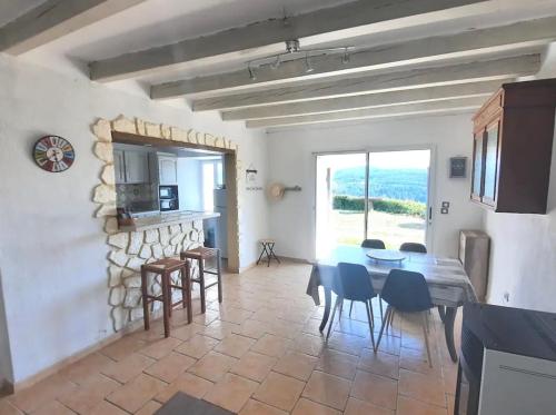 une cuisine et une salle à manger avec une table et des chaises dans l'établissement Domaine privé dans les bois, à Salettes