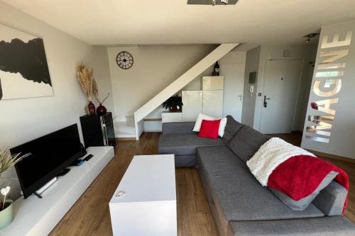 un salon avec un canapé et une télévision dans l'établissement Appartement 244 - Appartement en duplex contemporain et confortable proche, à Annecy