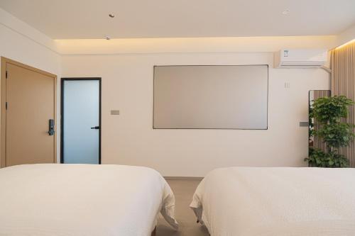 a bedroom with two beds and a blank screen at 一花一树音影民宿Tian Men mountian Branch in Wangjiazhai