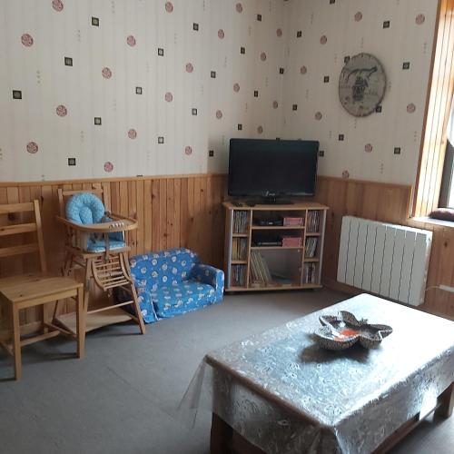 un salon avec une télévision et une table dans l'établissement appartement chez Chantal RDC 60m2 GERARDMER, à Gérardmer