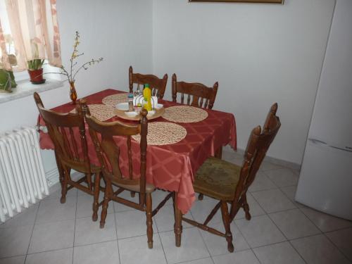 a dining room table with a red table cloth and chairs at Penzion Zavodsky in Český Krumlov