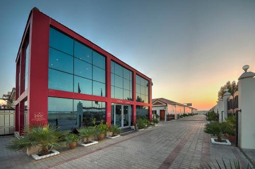 a red building with glass windows on a street at Royal Residence Hotel Apartments in Umm Al Quwain