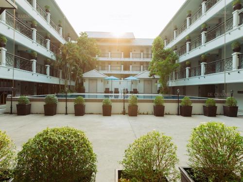 an empty courtyard of a building with potted plants at Decharme Hotel in Chiang Mai