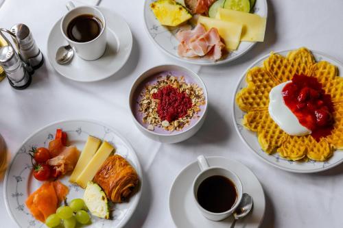 a table with plates of food and cups of coffee at Røisheim Hotel & Skysstasjon in Lom