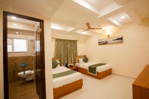 ein Hotelzimmer mit 2 Betten und einem Bad in der Unterkunft Hotel Grand Galaxy T nagar in Chennai