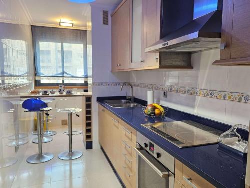 a kitchen with wooden cabinets and a blue counter top at PISO EN EL CENTRO DE NIGRAN CERCA DE PLAYA AMERICA in Nigrán