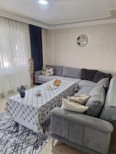 a living room with a couch and a table at 3 EGE Üniversite ve Hastanesi YAKINI Aileye-Firma Çalışanlarına uygun in Burunabat