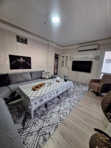 a living room with a couch and a table at 3 EGE Üniversite ve Hastanesi YAKINI Aileye-Firma Çalışanlarına uygun in Burunabat