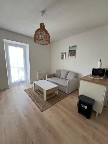un salon avec un canapé et une table basse dans l'établissement Grand studio cosy - A deux pas de la gare, à Agen