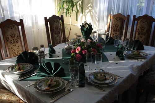 a table with a white table cloth and flowers on it at Pensjonat Rezydencja Zuzanna Bed&Breakfast Sucha Beskidzka in Sucha Beskidzka