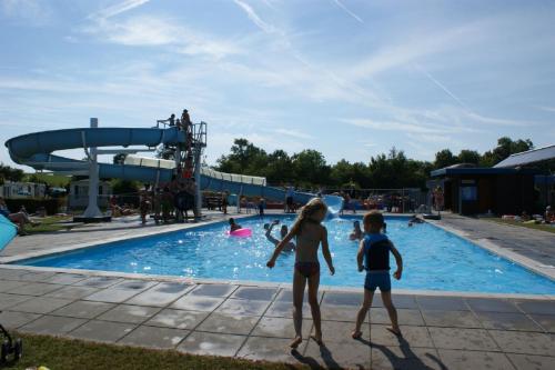 a group of children playing in a swimming pool at Do's Chalets in Baarland