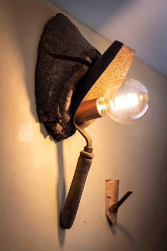 a light on a wall with a bottle and a knife at La grotte Dinant in Dinant