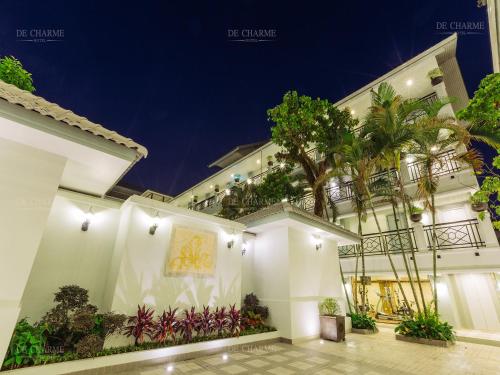 a facade of a building with a palm tree at Decharme Hotel in Chiang Mai