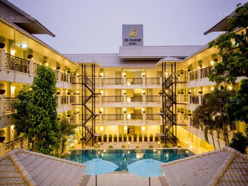 a hotel with a swimming pool and two umbrellas at Decharme Hotel in Chiang Mai