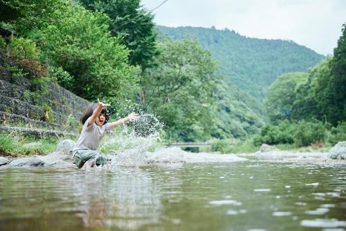 a woman playing in the water in a river at Rebe東吉野 in Washika