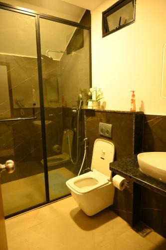 a bathroom with a shower and a toilet and a sink at Aura Farms - Private Pool Cottages in Rāmanagaram