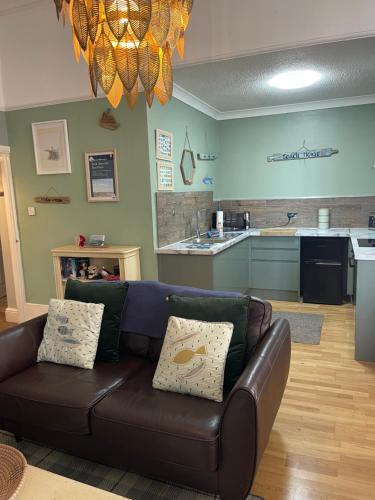 a living room with a couch and a kitchen at Beach House in Lytham St Annes