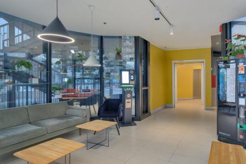 a lobby of a store with a couch and tables at B&B Hotel Milano Sesto Marelli in Sesto San Giovanni