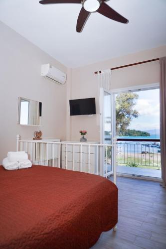 a bedroom with a red bed and a sliding glass door at Sandra's Beach House in Gouvia