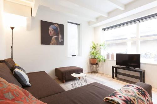 a living room with a couch and a flat screen tv at Lovely 4P-apt near Canals - Utrecht City Centre in Utrecht