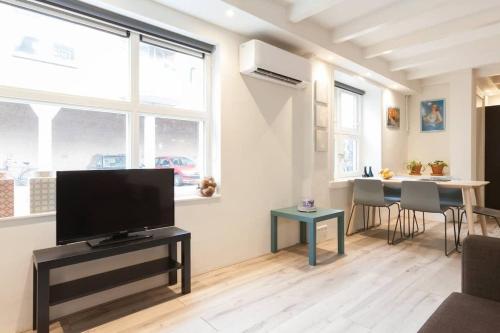 a living room with a flat screen tv on a table at Lovely 4P-apt near Canals - Utrecht City Centre in Utrecht