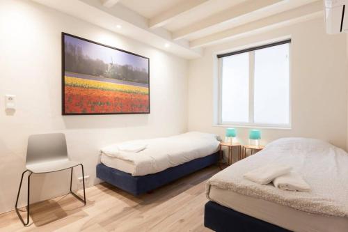 a bedroom with two beds and a painting on the wall at Lovely 4P-apt near Canals - Utrecht City Centre in Utrecht