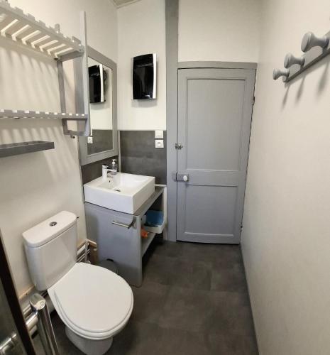 une salle de bain avec des toilettes blanches et un lavabo dans l'établissement Cap en vue, à Fécamp