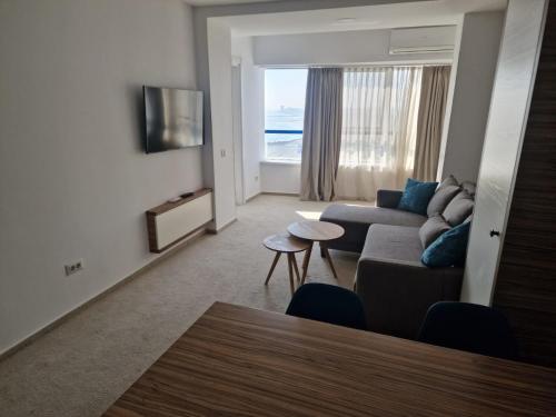 a living room with a couch and a table at Apartamente Topaz Sea View Olimp in Olimp