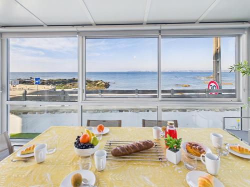 - une table avec de la nourriture et une vue sur l'océan dans l'établissement -AVEL DRO- Belle maison familiale vue mer corniche, à Concarneau