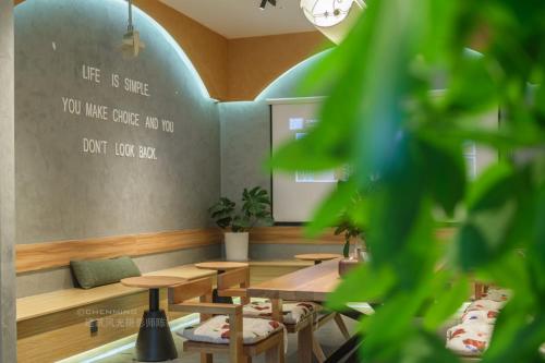 a restaurant with tables and a chalkboard on the wall at Denpa Inn-Lao Ximen Metro Station Branch in Shanghai