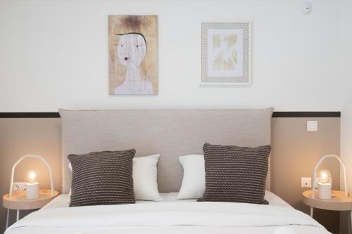 a bedroom with a bed with two candles on tables at Seaside Elegance Brand New 2BD Luxury Stay in Athens