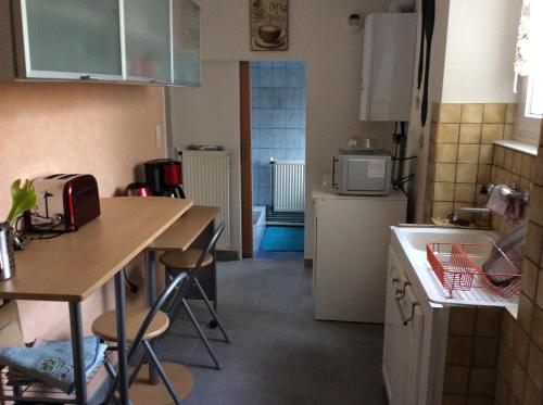 a small kitchen with a table and a counter at Gîte côté jardin in Ingersheim