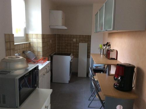 a small kitchen with a microwave and a table at Gîte côté jardin in Ingersheim