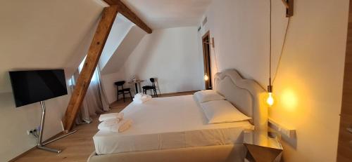 een slaapkamer met een wit bed en een televisie bij Santer Klause in Merano