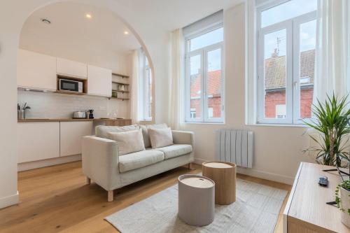 een woonkamer met een bank en een tafel bij Appartement T2 proche tramway et commodités in Tourcoing